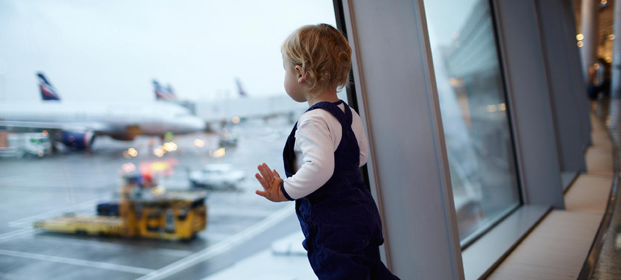 Enfant regarde par la fenêtre à l’aéroport